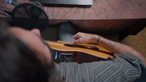 Hands of a Musician Playing Guitar in a Home Made Studio