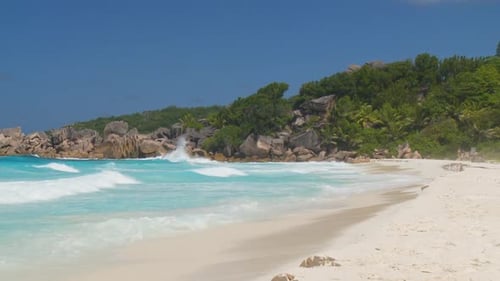 Waves Arriving on Sandy Beach With Rocks