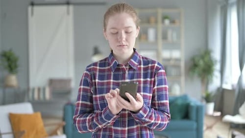 Junge Frau steht und benutzt Smartphone