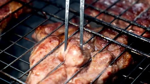 Big Juicy Stake From Pork Meat Inserted with Fork on Grill