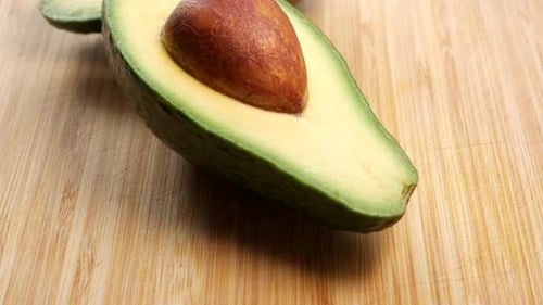 Avocat tranché sur une planche à découper en bois. PLAN PANORAMIQUE.