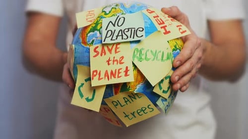Globe with Environmental Sticky Notes Held by Person
