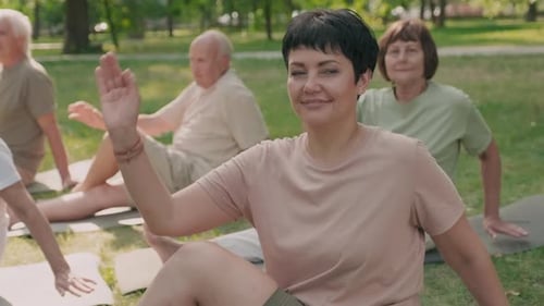 Adults Practicing Yoga Outside in the Park