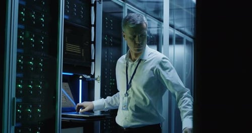 Technicians Work on a Laptop in a Data Center