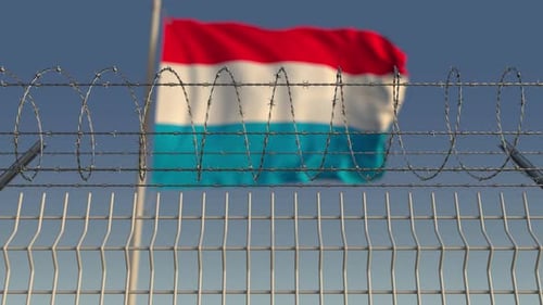 Flying Flag of Luxembourg Behind Barbed Wire Fence