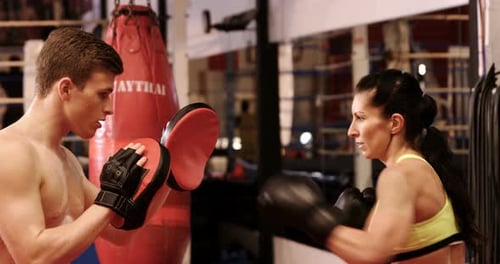 Woman Boxing with Trainer in Gym