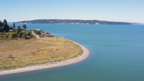 Vista aérea aérea curva de arena blanca y gaviota voladora desde arriba, isla Camano, Washington, Sunny Waterfront
