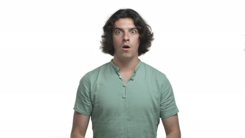 Attractive Hispanic Man Looking with Awe Standing Impressed with Something Awesome Wearing Green