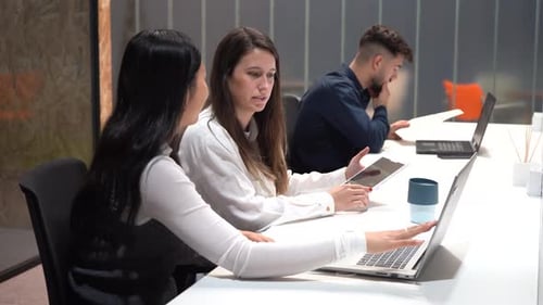 Diverse colleagues working at table in office