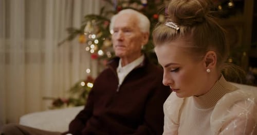 Senior Man and Young Woman Talking at Christmas