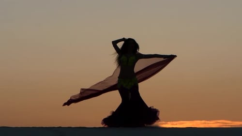 Graceful Woman Belly Dancing Silhouette at Sunset