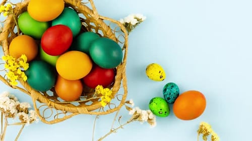 Colourful Easter Eggs in a Basket with Flowers