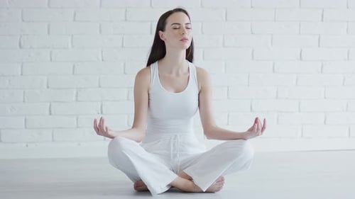 Woman Meditating in Yoga Position Indoors