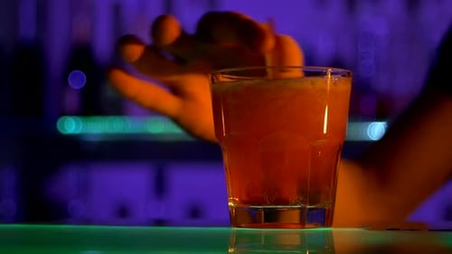 Barkeeper macht Cocktail, gießt an der Theke, mischt mit Tubuli im Dunkeln, Schüsse, langsam
