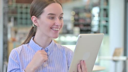Young Woman Smiling and Talking on Tablet