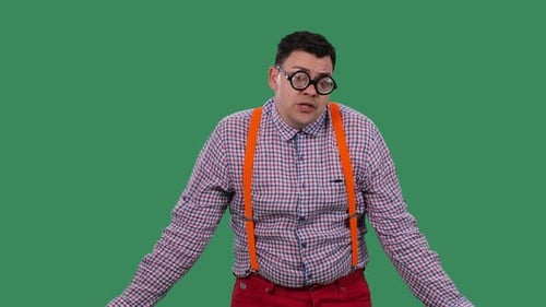 Man With Glasses Shrugs Against Green Background