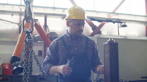 Opérateur de grue chargeant un composant métallique fini