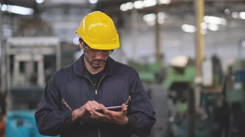 Smart factory worker or engineer or technician use tablet and act as manager then smile to camera