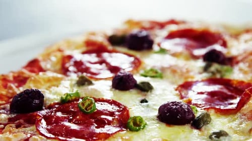 Baked pizza with avocado, cherry tomato and olive toppings