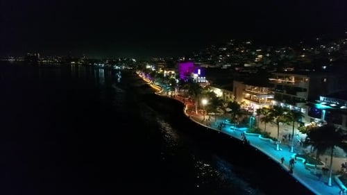 Nighttime Stroll Along Illuminated Coastal Boardwalk