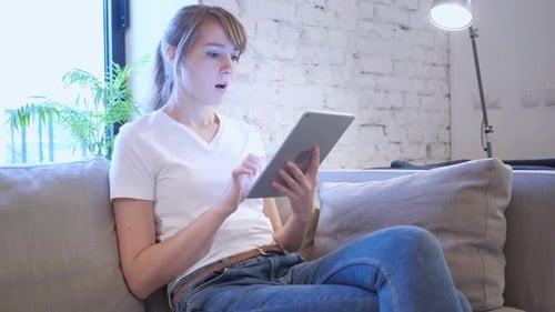 Woman Relaxing on Couch Using Tablet Device