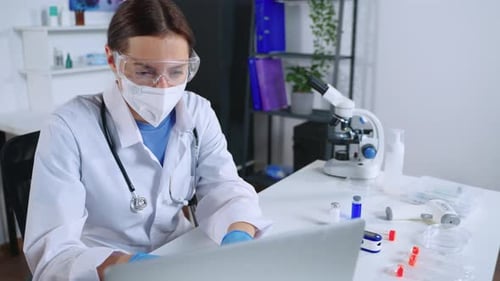 Stressed Doctor Working on Laptop in Laboratory