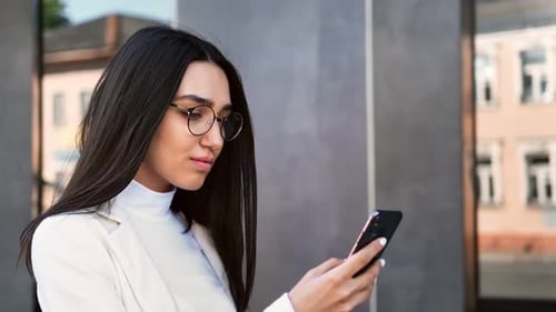 Stylish Woman Using Smartphone in Urban Setting