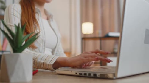 Young Woman Girl Using Laptop Computer Sitting at Table Working Typing on Keyboard From Home Office