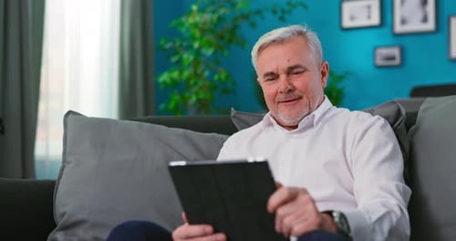 Man Using Tablet on Couch at Home