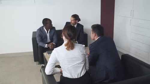 Four Adults Meeting in Office Discussing Business