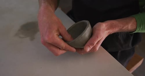 Close up view of male potter working on clay pots at pottery studio