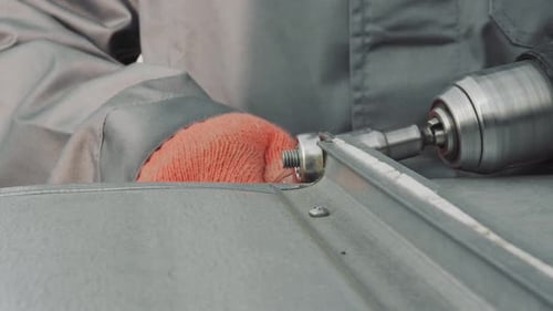 Metalworker Connects Metal Pieces with Power Drill