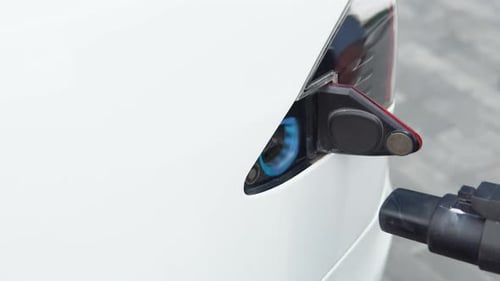 Close Up Man Inserting Power Cable Supply for Charging Electric Car