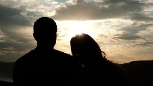 Couple Silhouetted Embracing at Sunset