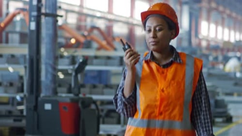 Black Female Factory Worker Talking on Radio Set