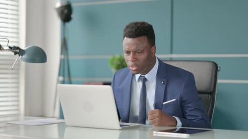 Homem africano furioso brigando, discutindo enquanto usa laptop