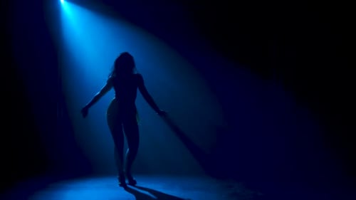 Hombre bailando música latina. Bachata, merengue, salsa. Grabado en un estudio oscuro con luces de neón en el