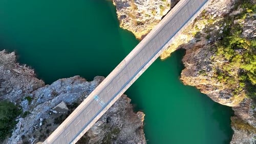 A car passes through a bridge over a river aerial view 4 K