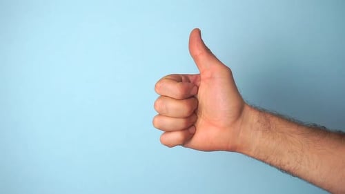 Hand Giving a Thumbs Up on Blue Background