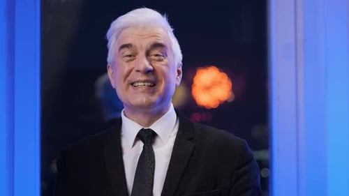 Smiling Man in Suit with Cityscape Background