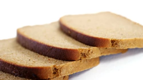 Slices of Stacked Brown Bread on White Background