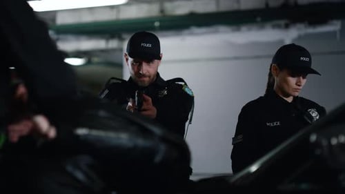 Police Officers on Guard with Gun in Garage