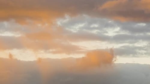 Time lapse footage of fast moving clouds on blue sky at sunset.