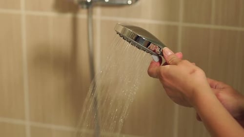 Nahaufnahme eines Mädchens macht das Wasser unter der Dusche an