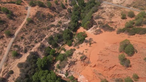 Aerial Slowmotion Shot of a Red Canyon or Fairy Stream at the Border of Desert in the Mui Ne Village