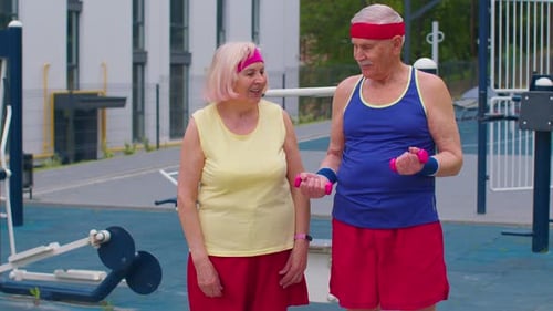 Active Senior Couple Lifting Weights Outdoors