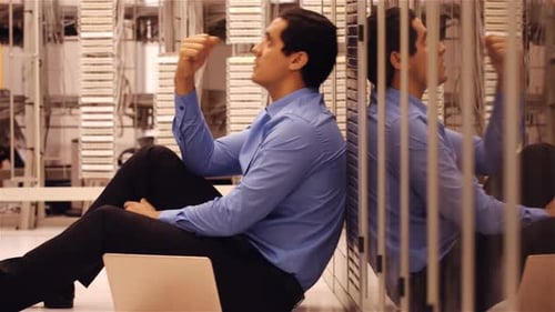 Stressed technician sitting in hallway