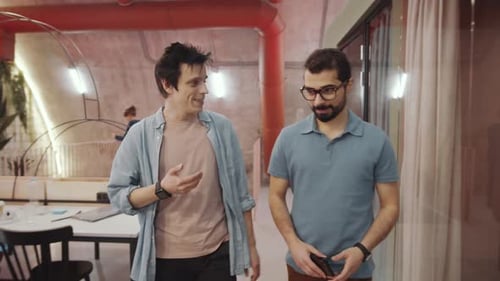 Male Colleagues Chatting and Walking in Coworking Space