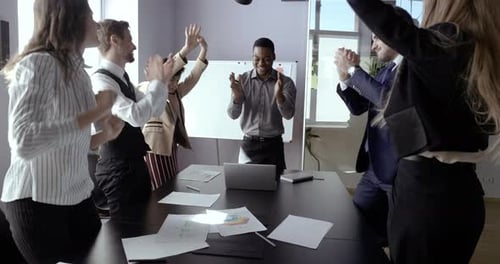 Team Celebrates Victory in Bright Modern Office