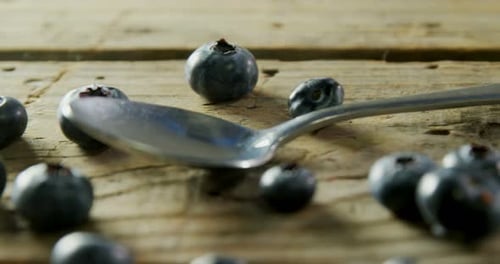 Fresh Blueberries and Spoon on Wooden Surface